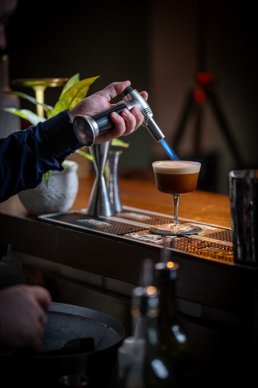 Vibrant Espresso Martini in a coupe glass, garnished with fresh fruit and illuminated by sophisticated bar lighting in St. Julian’s